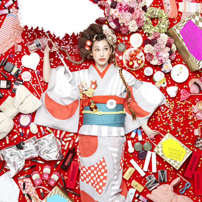 赤い背景に着物を着て物に囲まれる女性 レタッチ画像